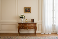 The framed panel hung above a Louis XV commode, the frame about the width of the flower vase and clock together (Samaritan woman panel)
