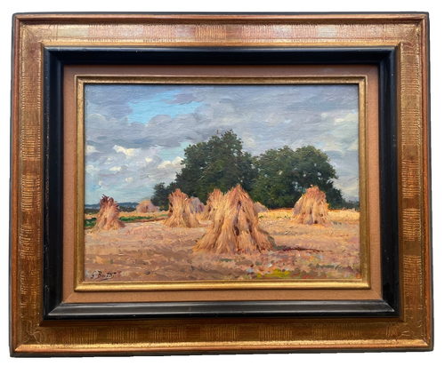 Five stooks of cut wheat in a stubble field under a clouded summer sky, a dark treeline behind, in a carved gilt and black frame (Gaston Bonfils)