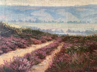 Macro of the middle distance where a single red roof shows among the trees in the hazy valley, the only building in the picture and the one warm accent in the blue