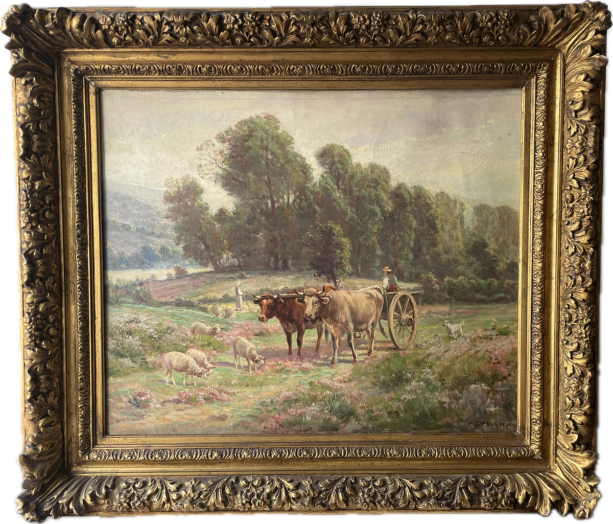 Two oxen under the yoke drawing a cart across flowering heather with sheep grazing, signed Desvarreux oil on canvas in a carved gilt frame