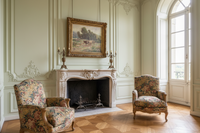 Framed pastoral landscape hung above a carved stone chimneypiece in a panelled salon (Desvarreux pastoral landscape)