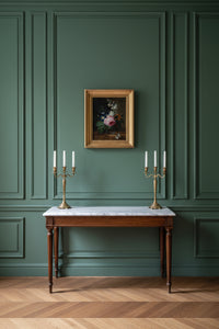Room setting showing the framed still life hung on a dark green panelled wall above a console (18th century Dutch floral still life)