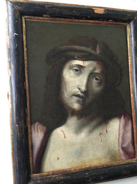 The Ecce Homo seen at an angle in its antique ebonised frame, showing the worn gilt fillet at the sight edge and the losses along the upper rail