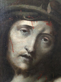 Macro of the face in the Ecce Homo showing the blood running from under the crown of thorns, the fine age craquelure across the flesh and the thorn tips at the temple