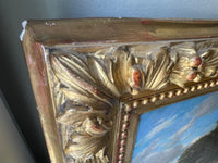 Close view of a frame corner, the acanthus and berry carving with the gold rubbed to the red bole and small losses of gesso along the outer edge
