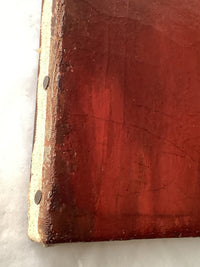 Detail of the lower left tacking edge showing the red paint of the coat carried over the turn of the canvas, two flat headed tacks set into the stretcher edge, and small losses and abrasion along the fold with the bare canvas showing through