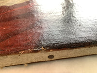 Raking light on the lower edge showing the pronounced craquelure network across the red and dark passages, the paint layer lifting and flaking along the fold with the pale canvas exposed beneath, and a rusted tack in the tacking margin below