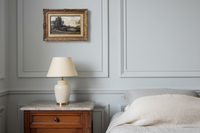 Signed Barbizon river landscape by Edmond Renault in a gilt frame above a nightstand in an elegant bedroom