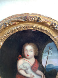 Close view of the child's face and the lamb, the lamb turned out to meet the viewer, with the red ribbon knot at the shoulder