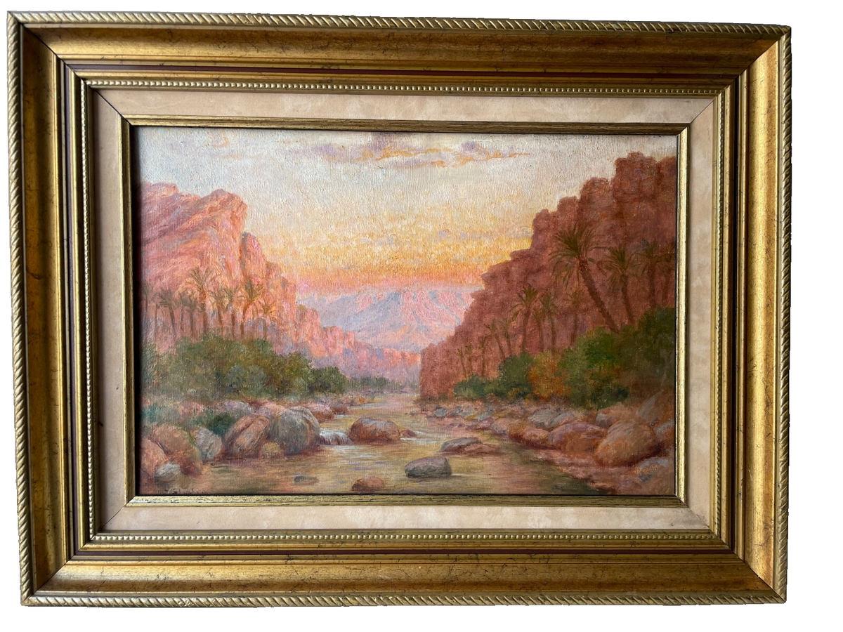 Signed orientalist oil painting of a palm oasis and rocky gorge at sunset, late 19th century, in a gilded wood frame